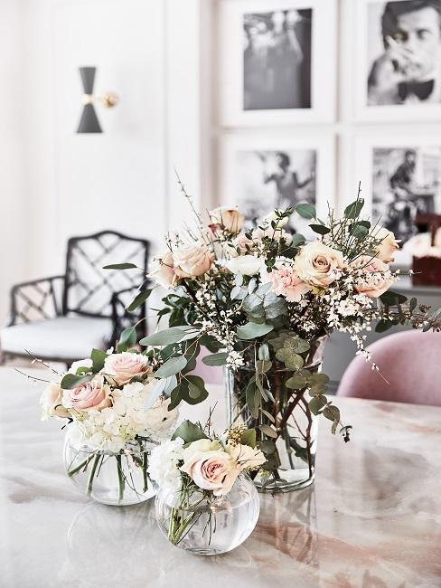 Drei verschiedene Vasen mit Rosen auf einem Tisch