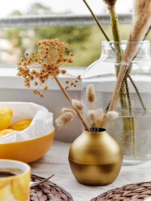 Kleine goldene Vase neben weiteren Dekoelementen