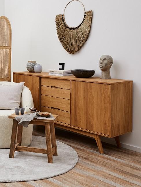 Metal ring decoration in gold on the wall above a chest of drawers.