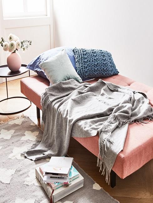 Gästebett in Rosa und gemütlichen Kissen und grauer Decke