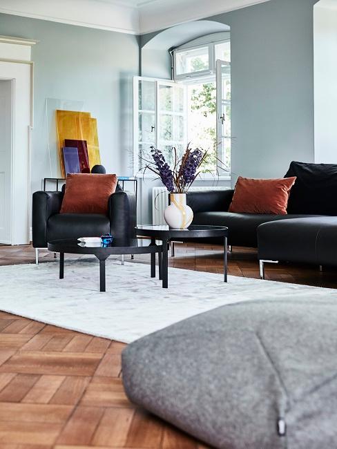 Wohnzimmer mit schwarzer Ledercouch im nordischen Chic