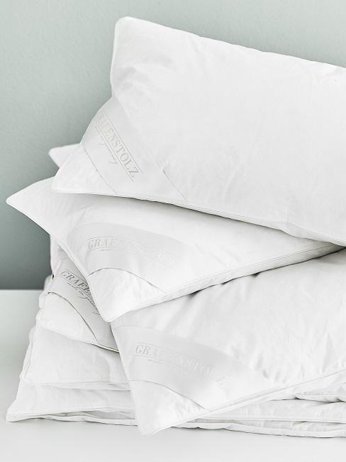 Ein Stapel an neuen Kissen auf einer weißen Ablage