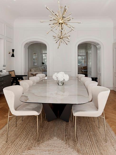 Long dining table with beige chairs and a small vase on the table