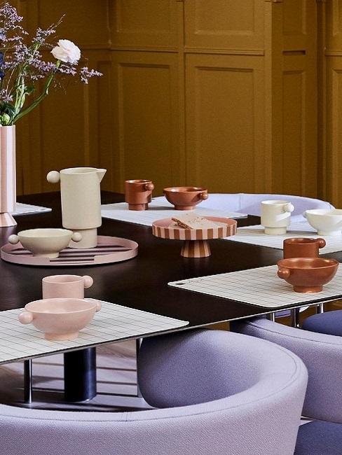 Modern gedeckter Tisch neben violetten Stühlen