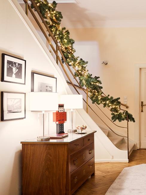 Holzkommode mit zwei Tischlampen neben Treppe mit Zweigen