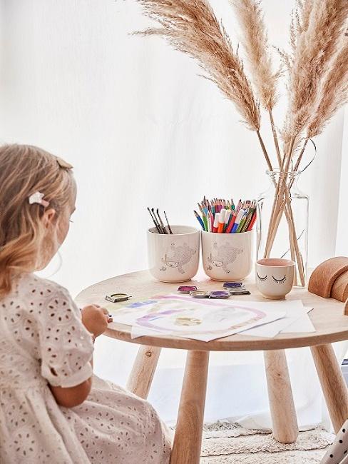 Homeschooling Mädchen sitzt am Tisch und malt