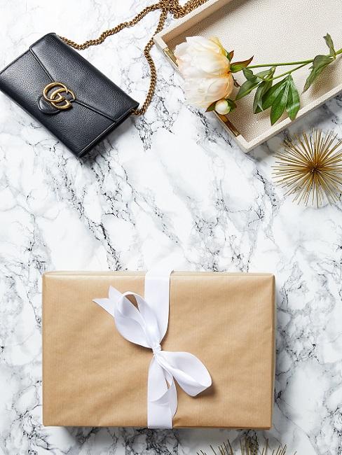 cadeau schoonmoeder 8 Cadeau met witte strik en gucci handtas op marmeren ondergrond