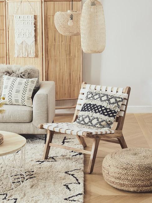Salon w stylu boho. Na plecionym parawanie wisi dekoracyjna makrama