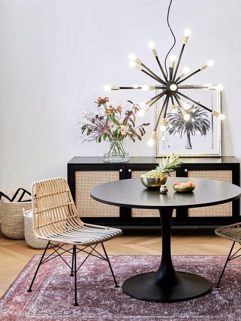 Salon w stylu nowoczesnym boho z fioletowym dywanem, bambusowym krzesłem oraz komoda z plecionka wiedenska