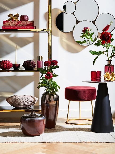 bordeaux Regal neben einem Hocker in Bordeaux und einem kleinen Tisch, sehr viel Deko in Bordeaux