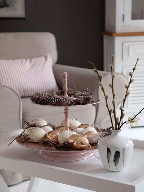 Couchtisch mit Etagere mit Ostereiern neben einer Vase
