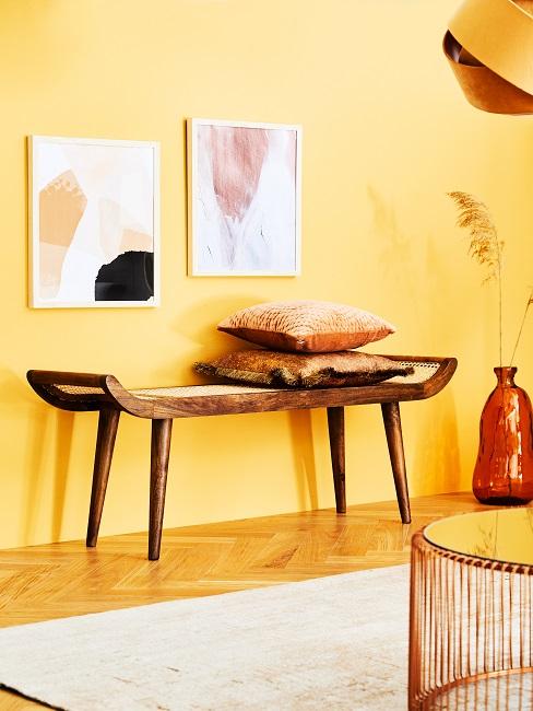 Gelbes Zimmer mit Holz-Dekoelementen und Wandbildern