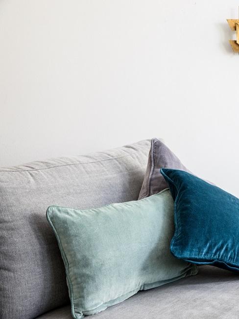 Samtkissen auf grauer Couch