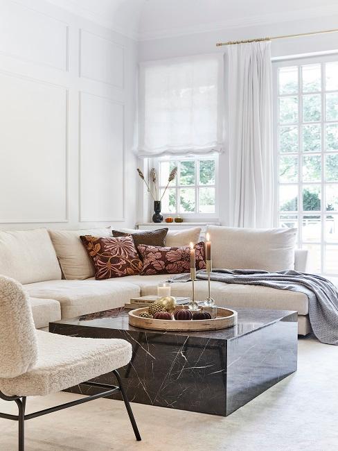 Helles Wohnzimmer mit heller Couch und schwarzem Marmortisch