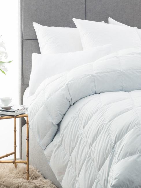 Bett waschen Weiße Bettdecke im Bett mit weißen Kissen.