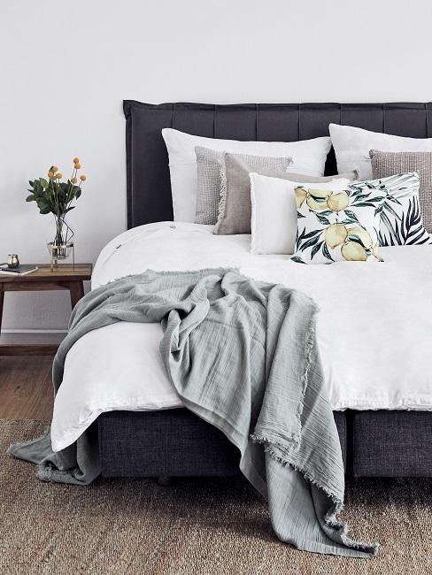 bettwäsche material Schlafzimmer mit einem dunkelblauen Bett mit Bettwäsche aus einem leichten Material in Weiß, geeignet für den Sommer