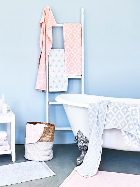Hellblaue Wandfarbe im Badezimmer mit Badewanne, Leiter und Dekokorb