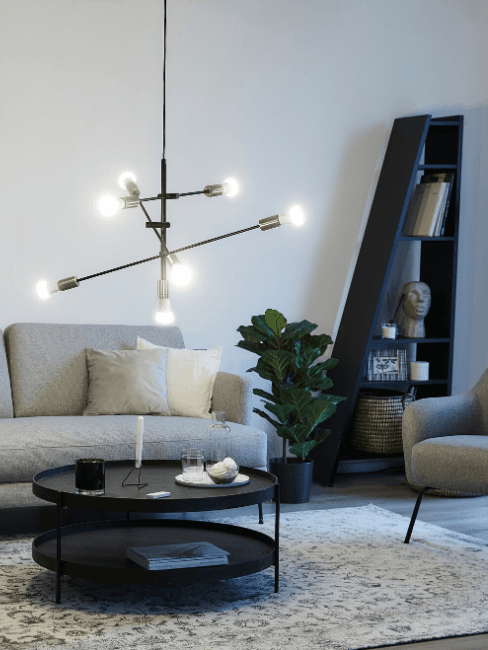Soggiorno moderno Soggiorno moderno con lampada a sospensione, divano grigio e tavolino tondo