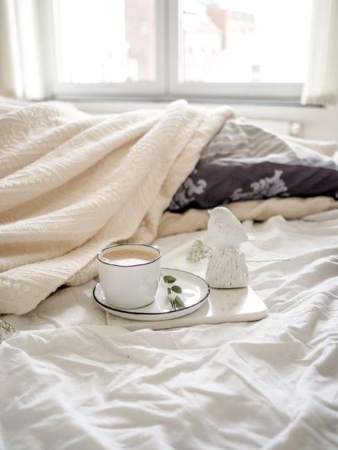 cocooning camera da letto con letto sfatto e caffè