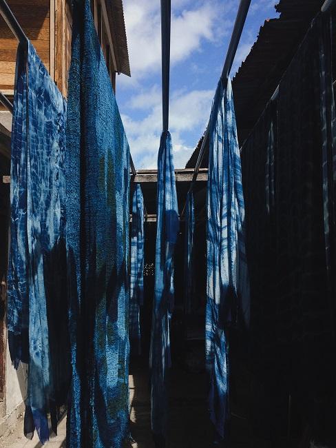 Shibori Shibori Textilien aufgehängt auf Wäscheleinen zwischen Häusern