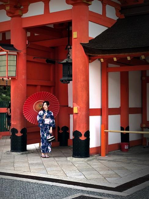 Japanische Frau in Shibori Kimono vor einem Haus