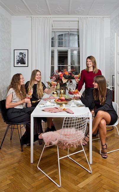 Junggesellinnenabschied Frauen beim Anstoßen in der Wohnung an einem Tisch