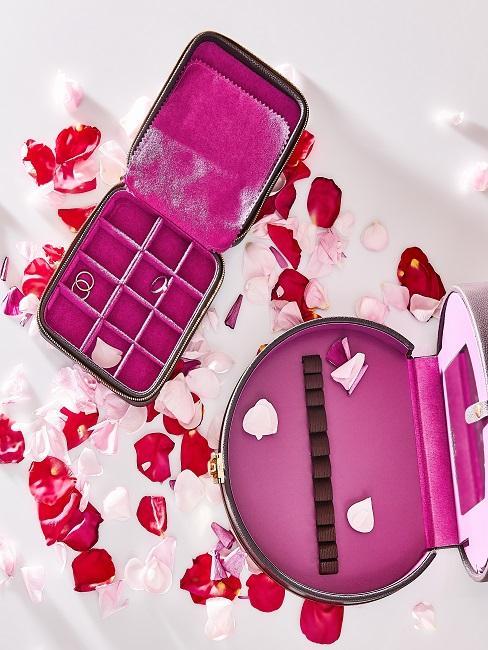 Pinke Schmuckboxen neben Rosenblüten