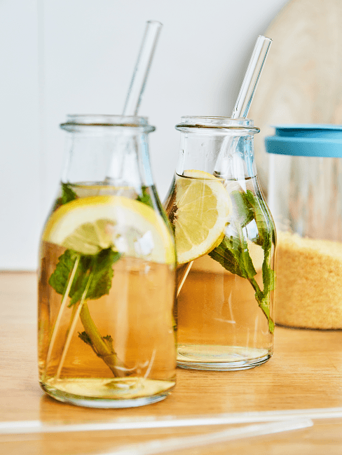 Infused Water Zwei Glasflaschen mit Infused Water aus Zitrone und Minze