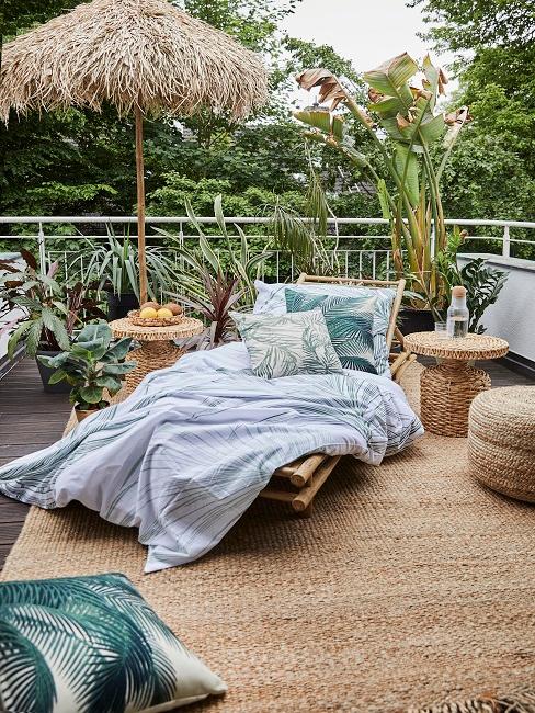 Terrasse mit Rattanmöbeln, einer Bambusliege und Pflanzen