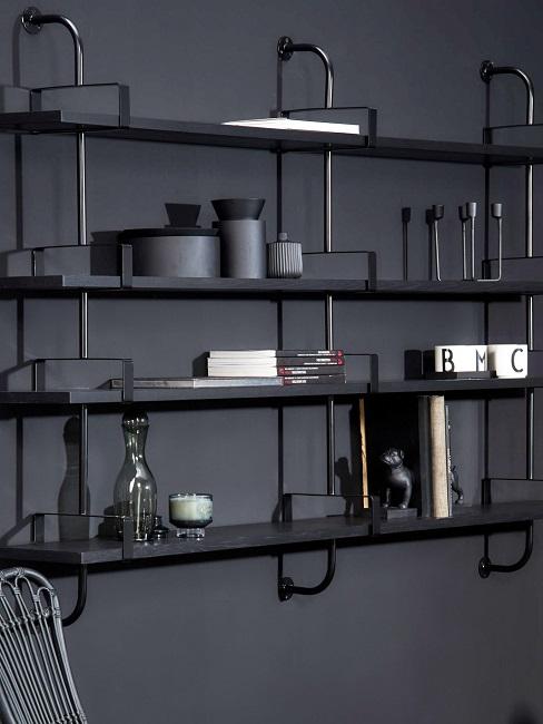 Regal anbringen Ein schwarzes Metallregal an einer schwarzen Wand mit Dekoobjekten dekoriert.