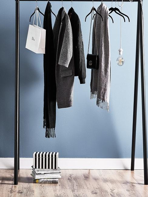 Schwarze Kleiderstange vor blauer Wand