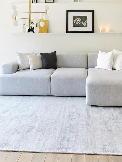 Großes graues Sofa auf großem Teppich