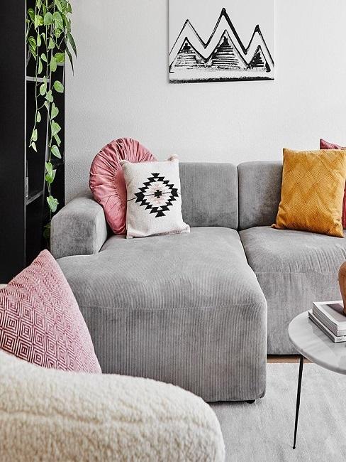 Hellgraue Cord Couch mit bunten Kissen