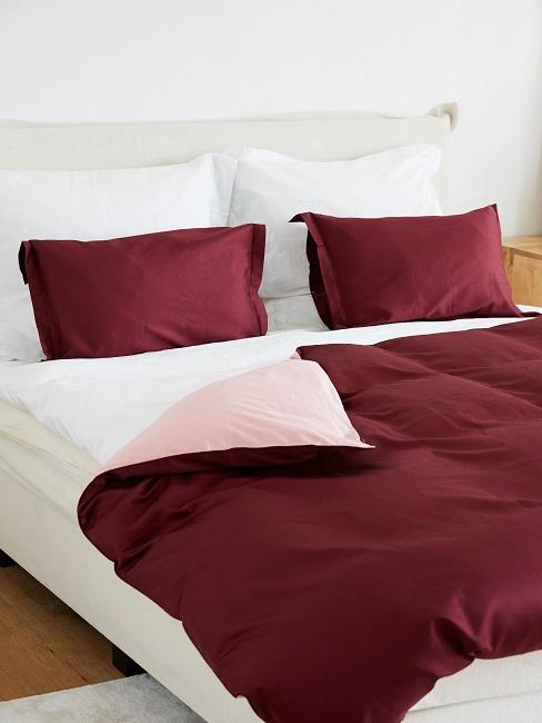 Doppelbett mit rot-weißer Bettwäsche