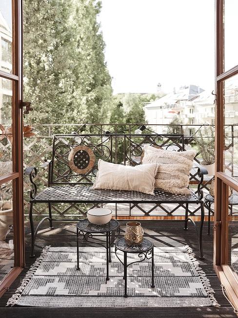 Französischer Balkon mit Sitzbank und Kissen, Teppich und zwei kleinen Beistelltischen