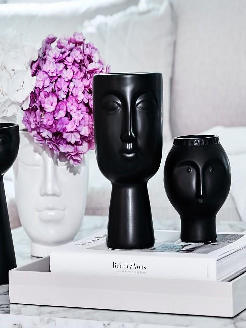 White and black vase with face on table