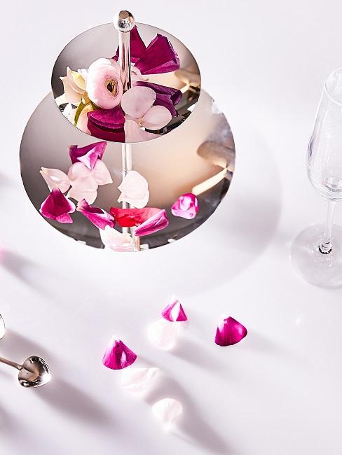 Cake stand as a table decoration with rose petals