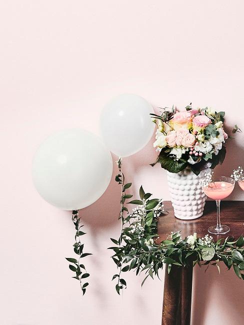 Balloons in white tied to a table with floral decorations