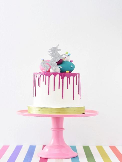 Cake with unicorn decoration on a cake stand in the kitchen