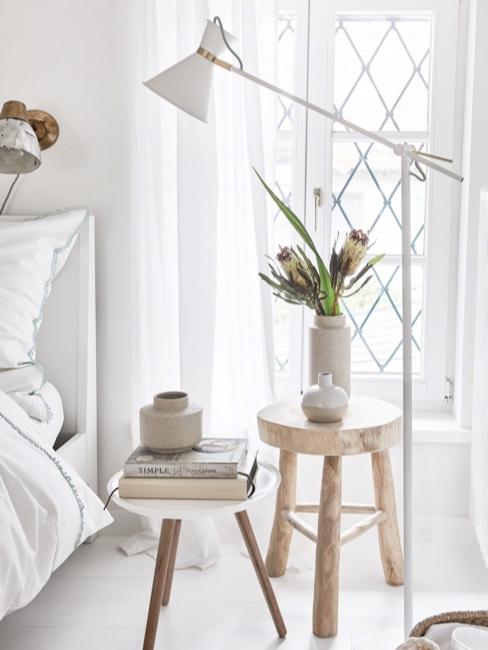 Two bedside tables next to bed with different bedside table decoration