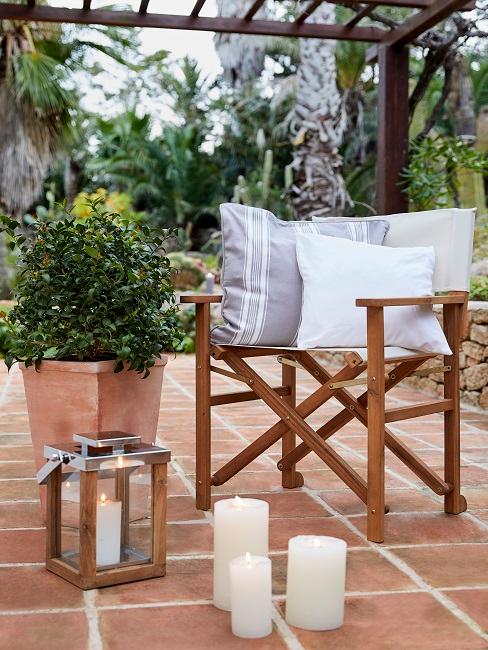 Gartenstuhl neben Dekoelementen auf einer Terasse