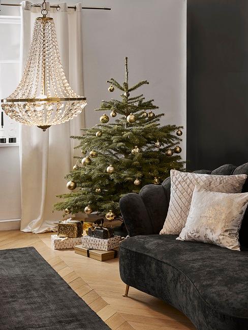 Elegantly decorated fir tree next to dark velvet couch
