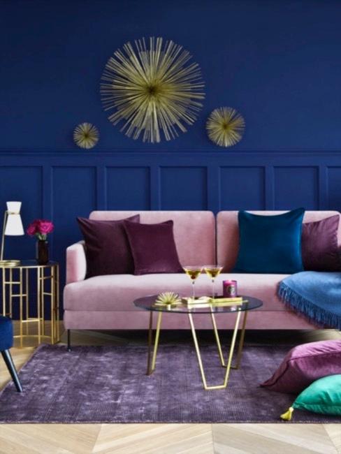 Raum mit kobaltblauer Wand, rosa Sofa und Kissen in Blau- und Violetttönen