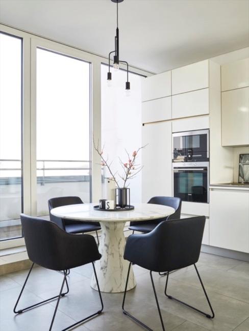 Cocina blanca con sillas negras de estilo minimalista