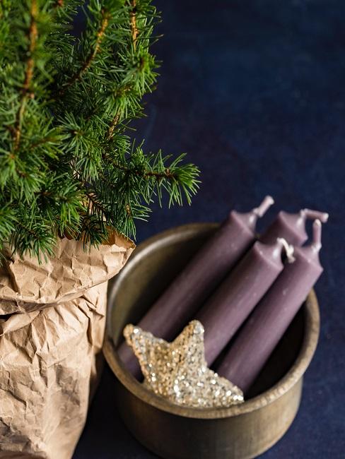Schale mit Kerzen und Stern neben Weihnachtsbaum