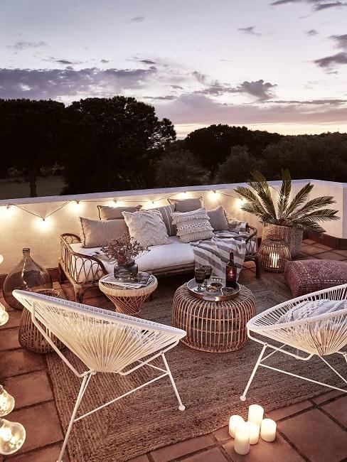 Outdoor Trends Banner Outdoor Wohnzimmer mit Lichterketten, Beistelltischen, Daybed und Acapulco Chairs