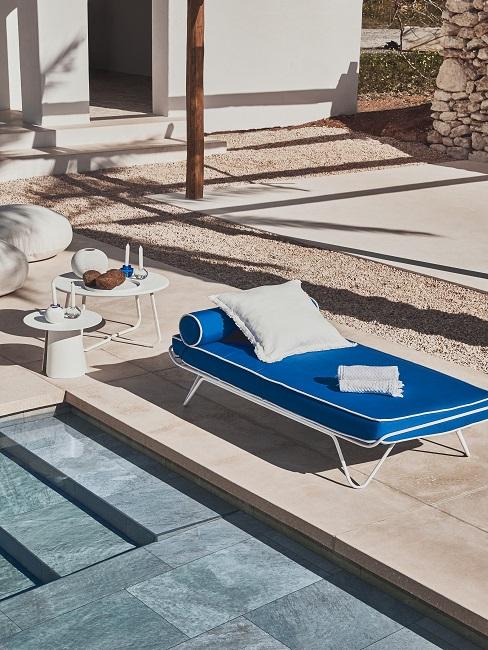 Blaues Daybed mit weißem Kissen am Pool