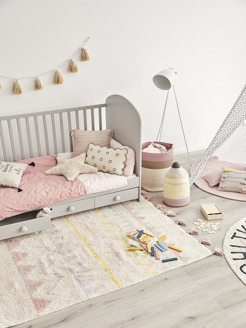 Kinderzimmer in Rosa und Gelb mit Kissen, Teppich, Girlande und Tipi
