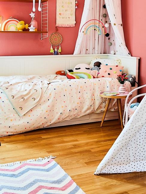 Kinderzimmer mit roten Wänden, weißen Möbeln und gepunkteter Bettwäsche