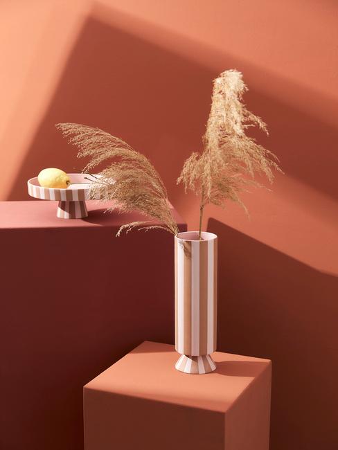 Jarrón con plantas y fondo de color terracota